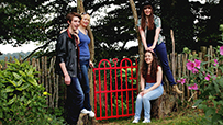 John, Rebecca, Orlaith and Emily Kelly in informal pose by a red garden gate